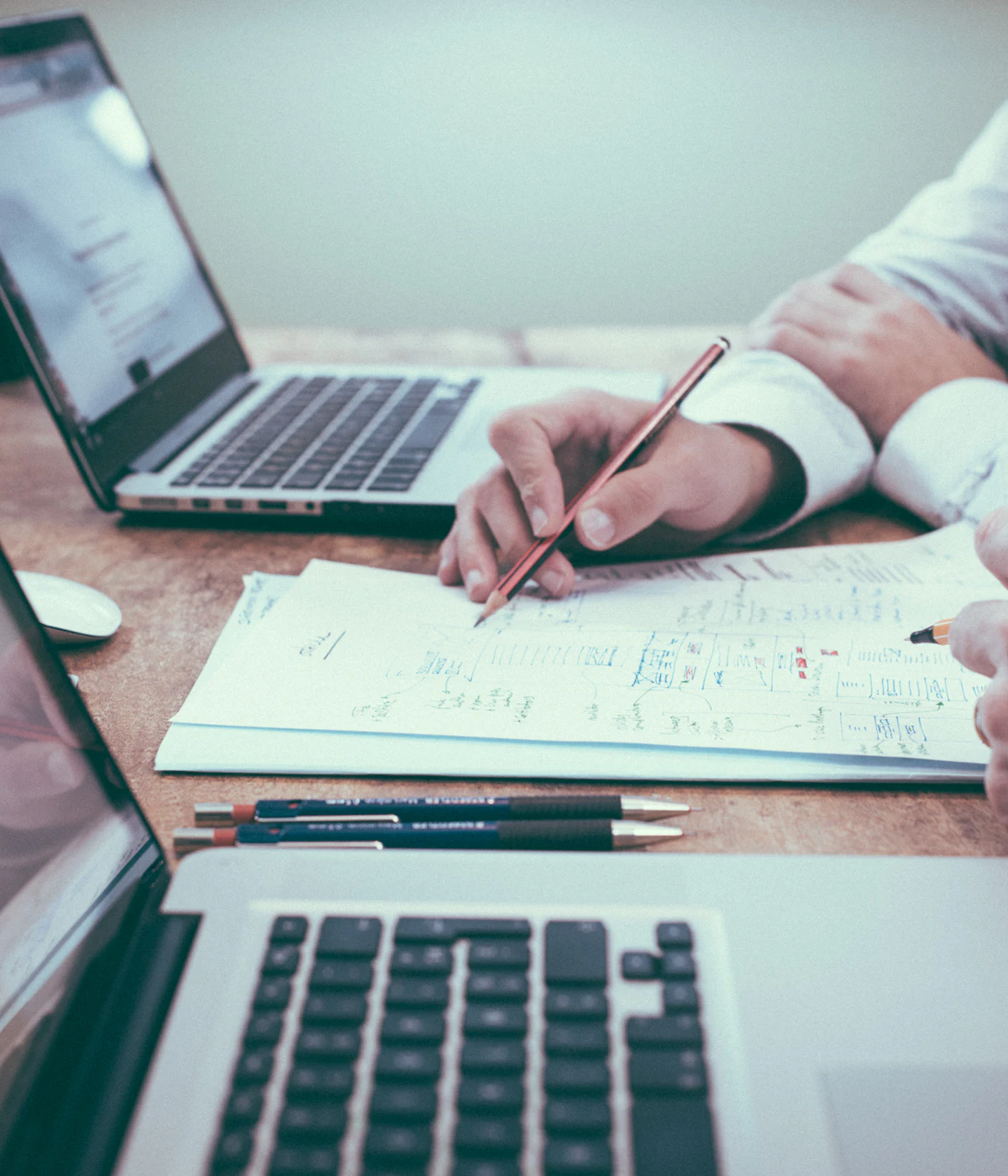Financial documents and a laptop being reviewed at a desk